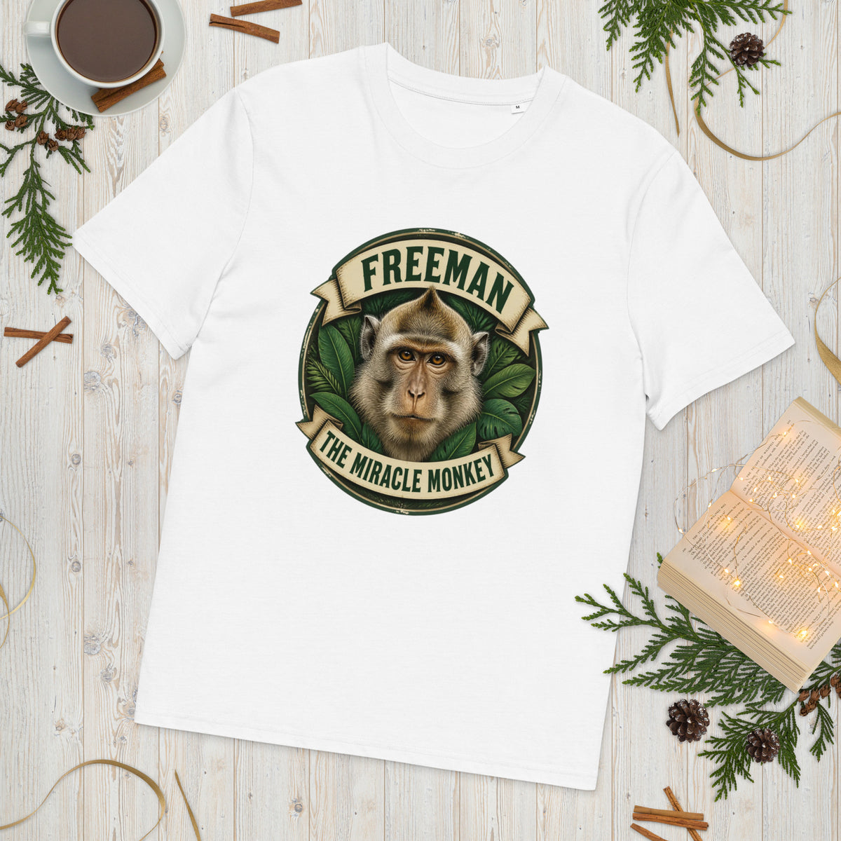 Freeman The Miracle Monkey t-shirt med abe i grønt badge i farven hvid, lagt på et lyst træbord