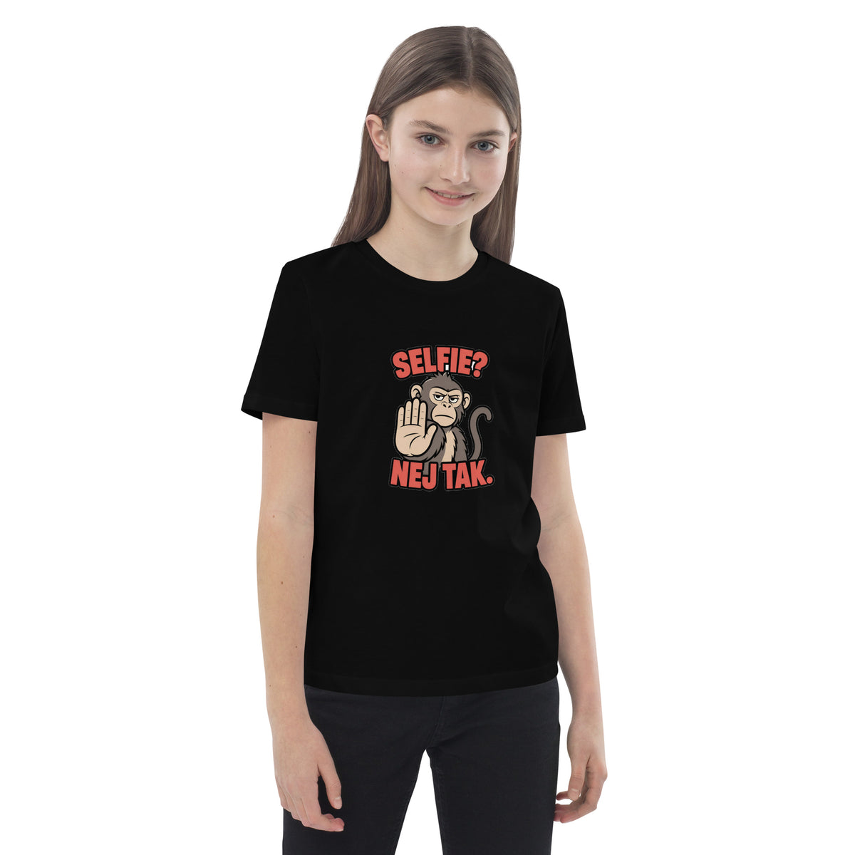Børne t-shirt med teksten Selfie? Nej tak og en abe der holder hånden op i farven sort, båret af en pige