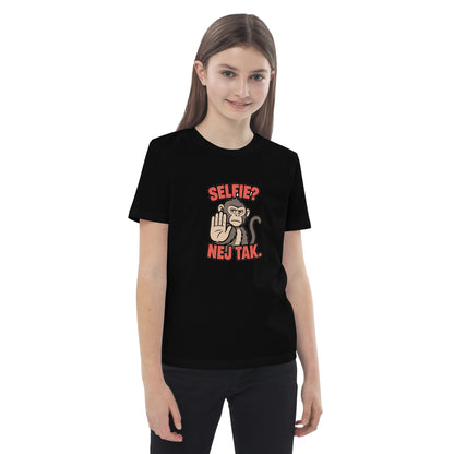 Børne t-shirt med teksten Selfie? Nej tak og en abe der holder hånden op i farven sort, båret af en pige