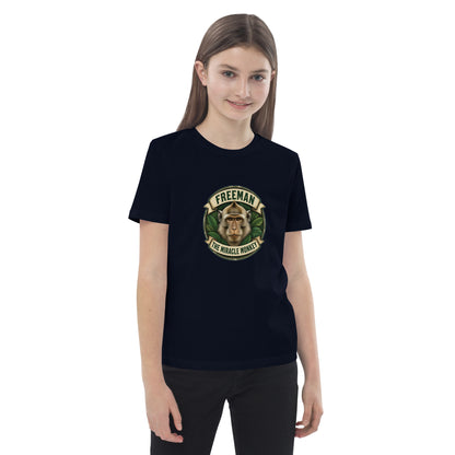 Børne t-shirt med Freeman The Miracle Monkey badge med en abe i grønt i farven marineblå, båret af en pige