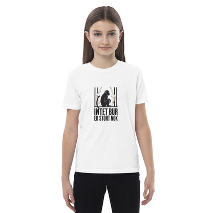 Hvid børne t-shirt med teksten Intet bur er stort nok og en abe bag tremmer, båret af en pige