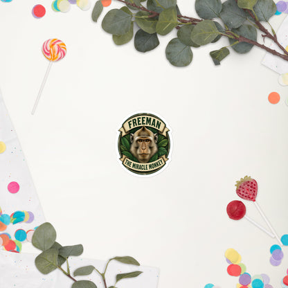 Klistermærke med Freeman The Miracle Monkey badge med en abe i grønt, 7,5 x 7,5 cm, på en hvid baggrund med blomster