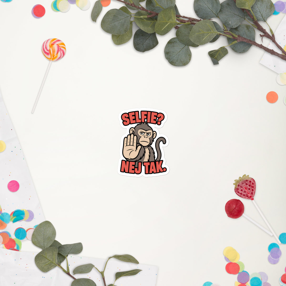 Klistermærke med teksten Selfie? Nej tak og en abe der holder hånden op, 7,5 x 7,5 cm, på en hvid baggrund med blomster