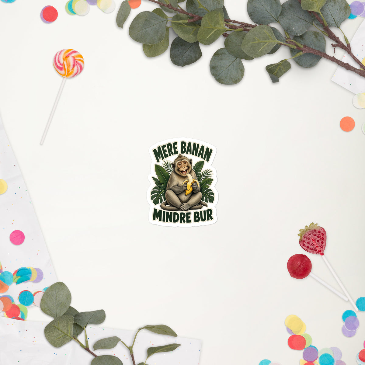 Klistermærke med teksten Mere banan, mindre bur og en glad abe med en banan, 7,5 x 7,5 cm, på en hvid baggrund med blomster