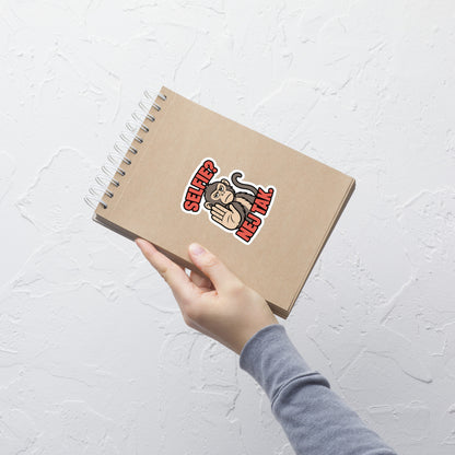Klistermærke med teksten Selfie? Nej tak og en abe der holder hånden op, 10 x 10 cm, på en notesbog