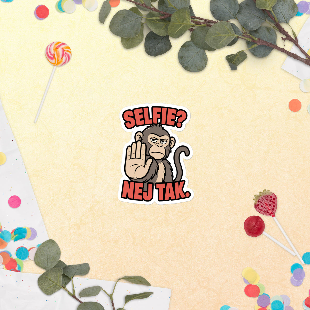 Klistermærke med teksten Selfie? Nej tak og en abe der holder hånden op, 10 x 10 cm, på en lys baggrund med blomster