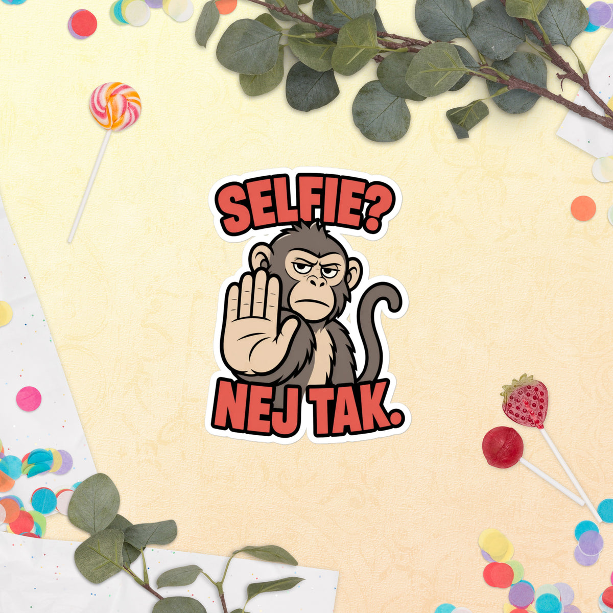 Klistermærke med teksten Selfie? Nej tak og en abe der holder hånden op, 14 x 14 cm, på en lys baggrund med blomster