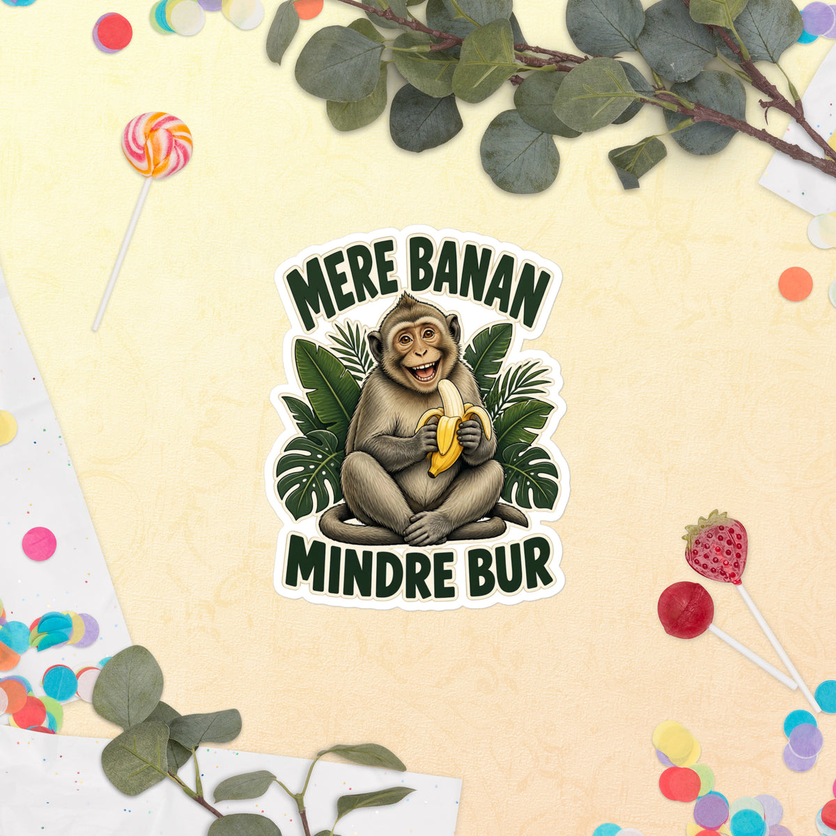 Klistermærke med teksten Mere banan, mindre bur og en glad abe med en banan, 14 x 14 cm, på en lys baggrund med blomster