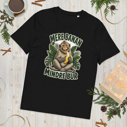 Abe t-shirt med teksten Mere banan, mindre bur i farven sort, lagt på et lyst træbord