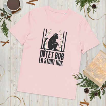 T-shirt med teksten Intet bur er stort nok i farven lyserød, lagt på et lyst træbord