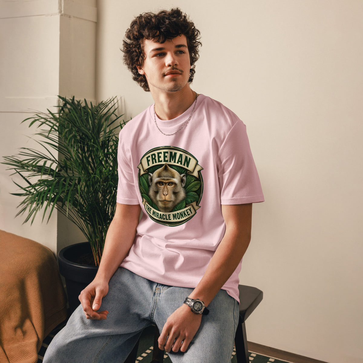 Freeman The Miracle Monkey t-shirt med abe i grønt badge i farven lyserød, båret af en ung mand