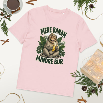 Abe t-shirt med teksten Mere banan, mindre bur i farven lyserød, lagt på et bord med kaffe og grønt