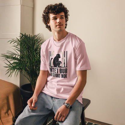 T-shirt med teksten Intet bur er stort nok i farven lyserød, båret af en ung mand