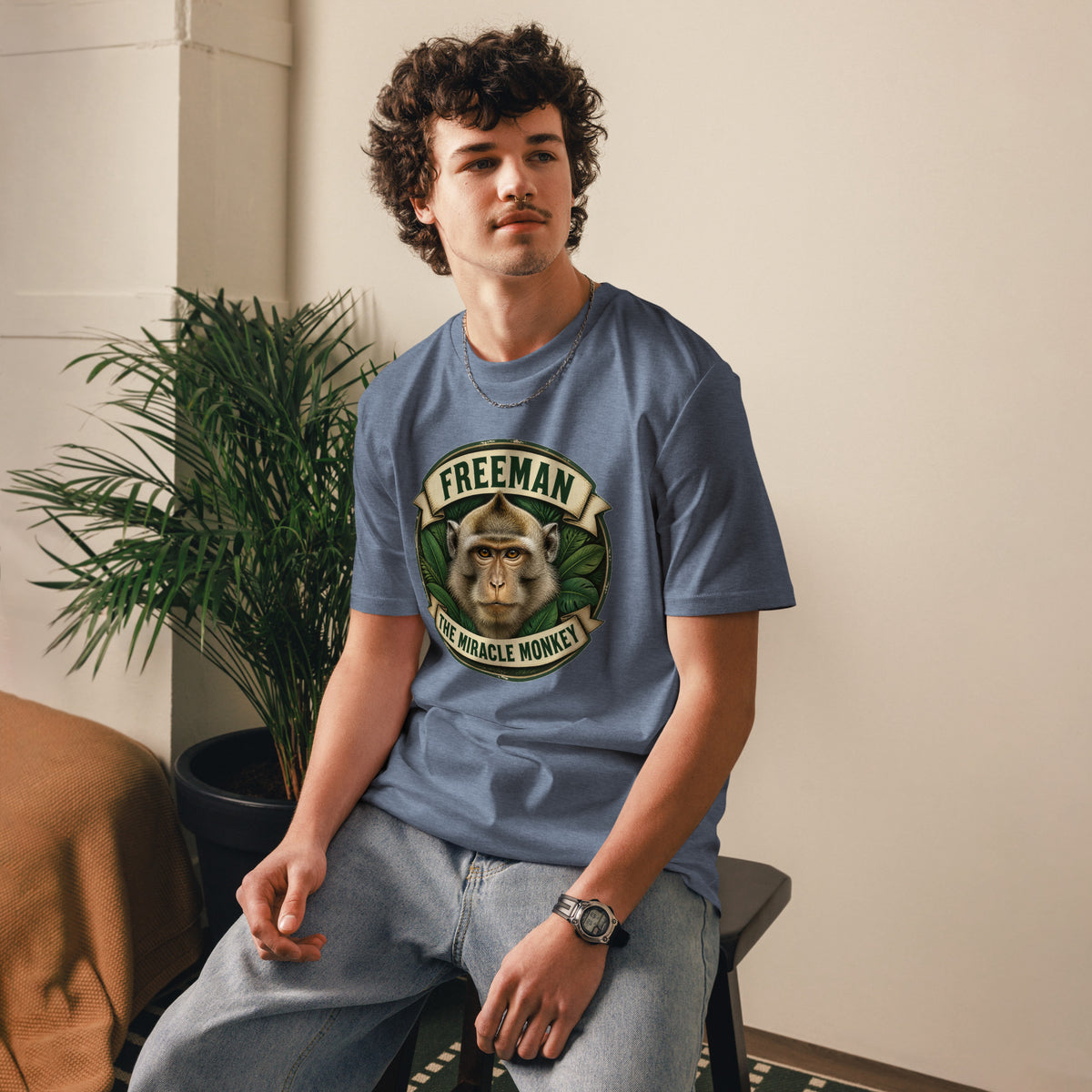 Freeman The Miracle Monkey t-shirt med abe i grønt badge i farven blågrå meleret, båret af en ung mand