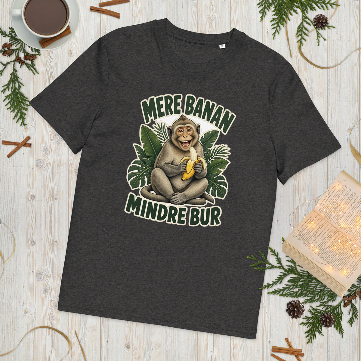 Abe t-shirt med teksten Mere banan, mindre bur i farven mørkegrå meleret, lagt på et lyst træbord