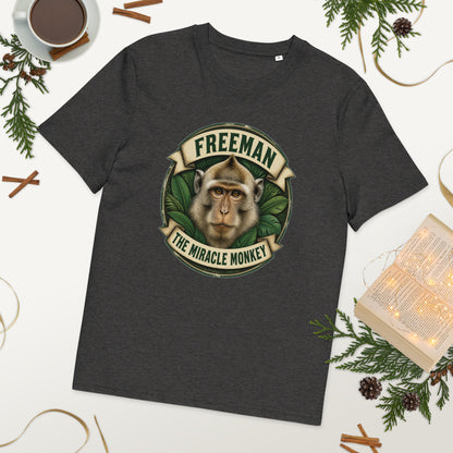 Freeman The Miracle Monkey t-shirt med abe i grønt badge i farven mørkegrå meleret, lagt på et bord med kaffe og grønt