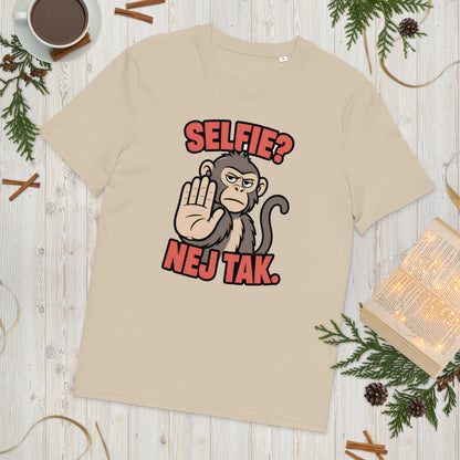 Sjov abe t-shirt med teksten Selfie? Nej tak. i farven sand, lagt på et lyst træbord