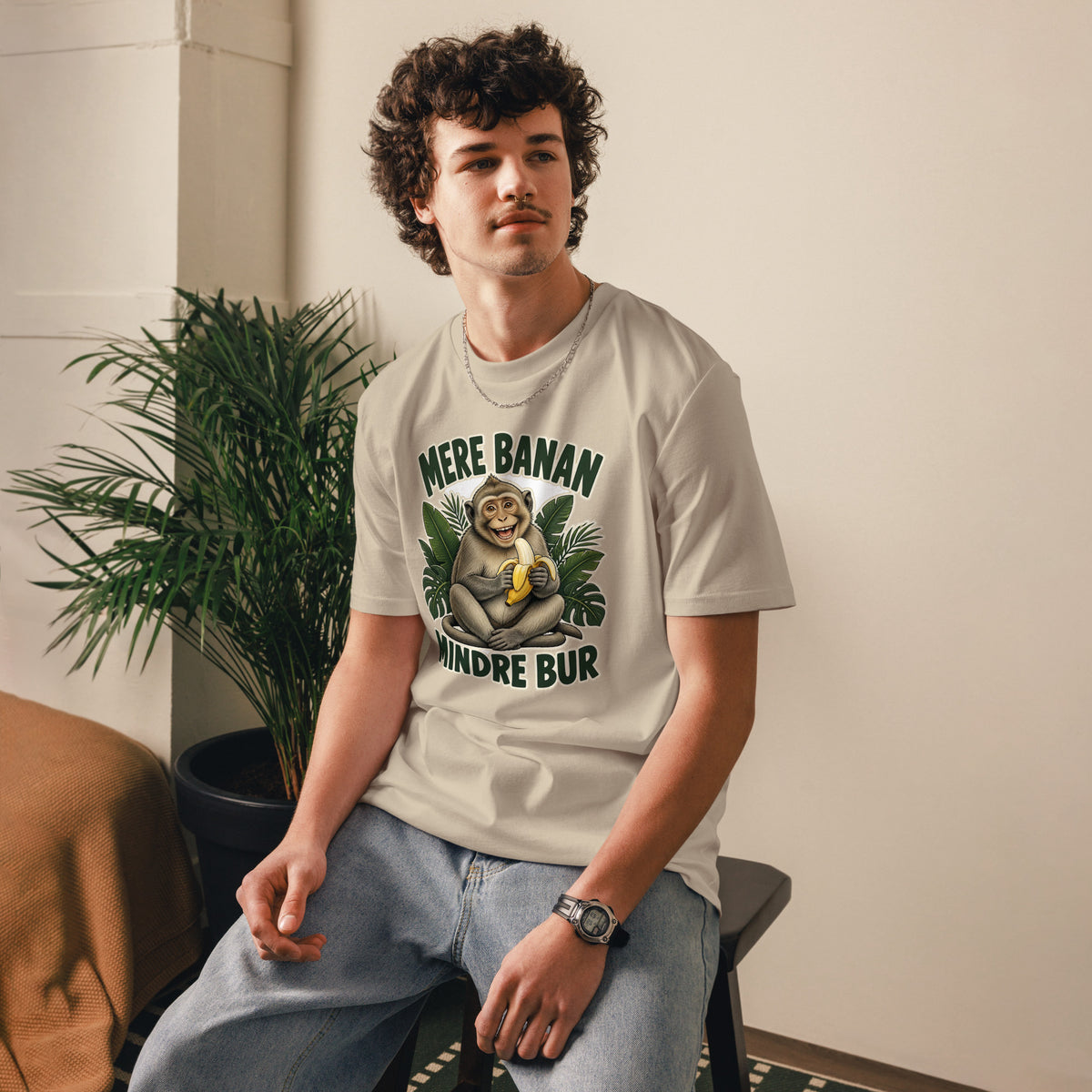 Abe t-shirt med teksten Mere banan, mindre bur i farven sand, båret af en ung mand