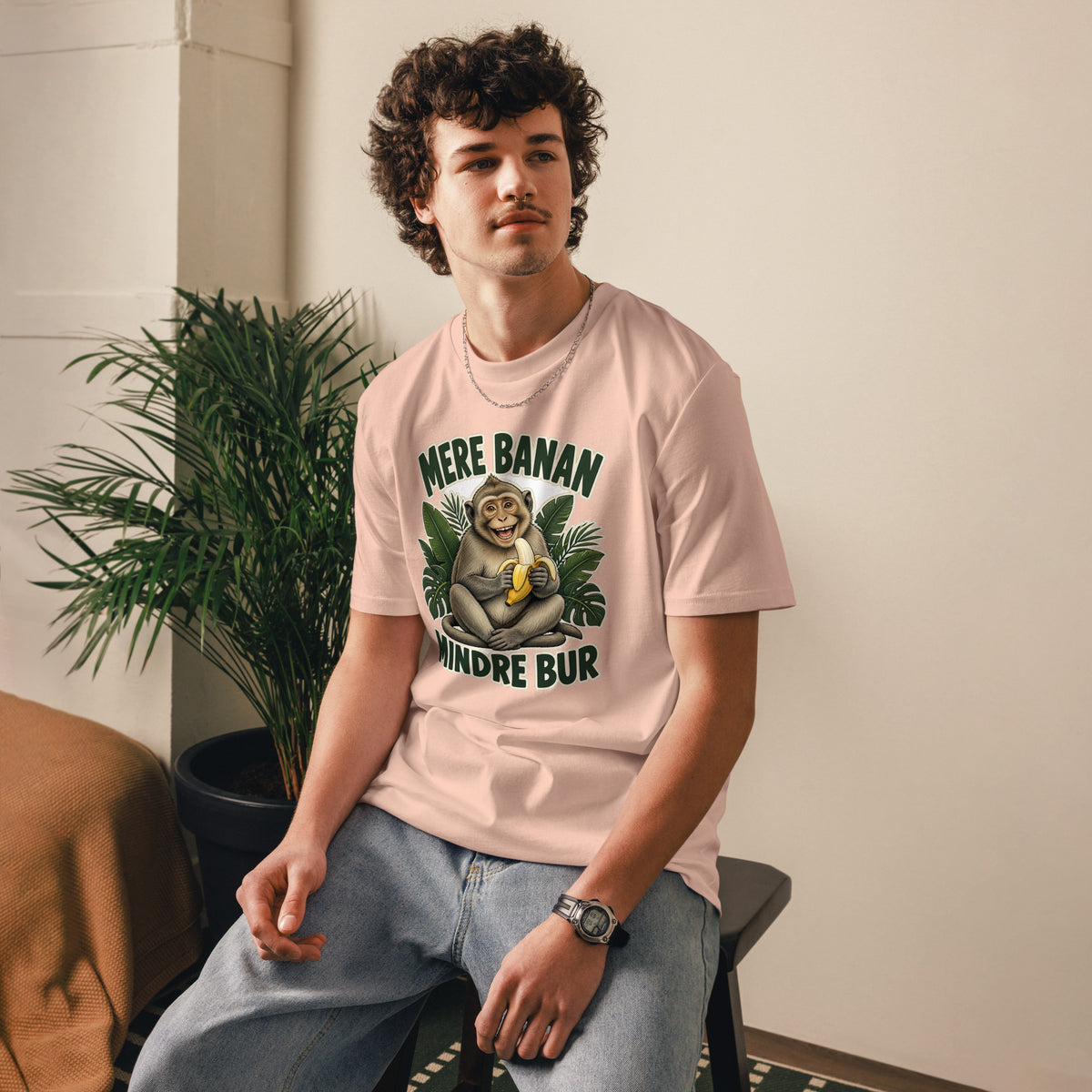 Abe t-shirt med teksten Mere banan, mindre bur i farven fersken, båret af en ung mand