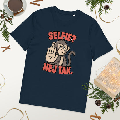 Sjov abe t-shirt med teksten Selfie? Nej tak. i farven marineblå, lagt på et bord med kaffe og grønt