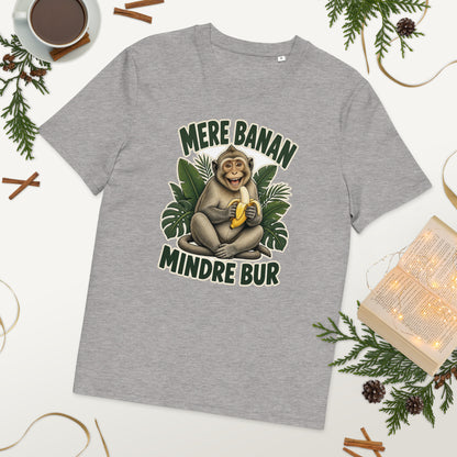 Abe t-shirt med teksten Mere banan, mindre bur i farven lysegrå meleret, lagt på et bord med kaffe og grønt
