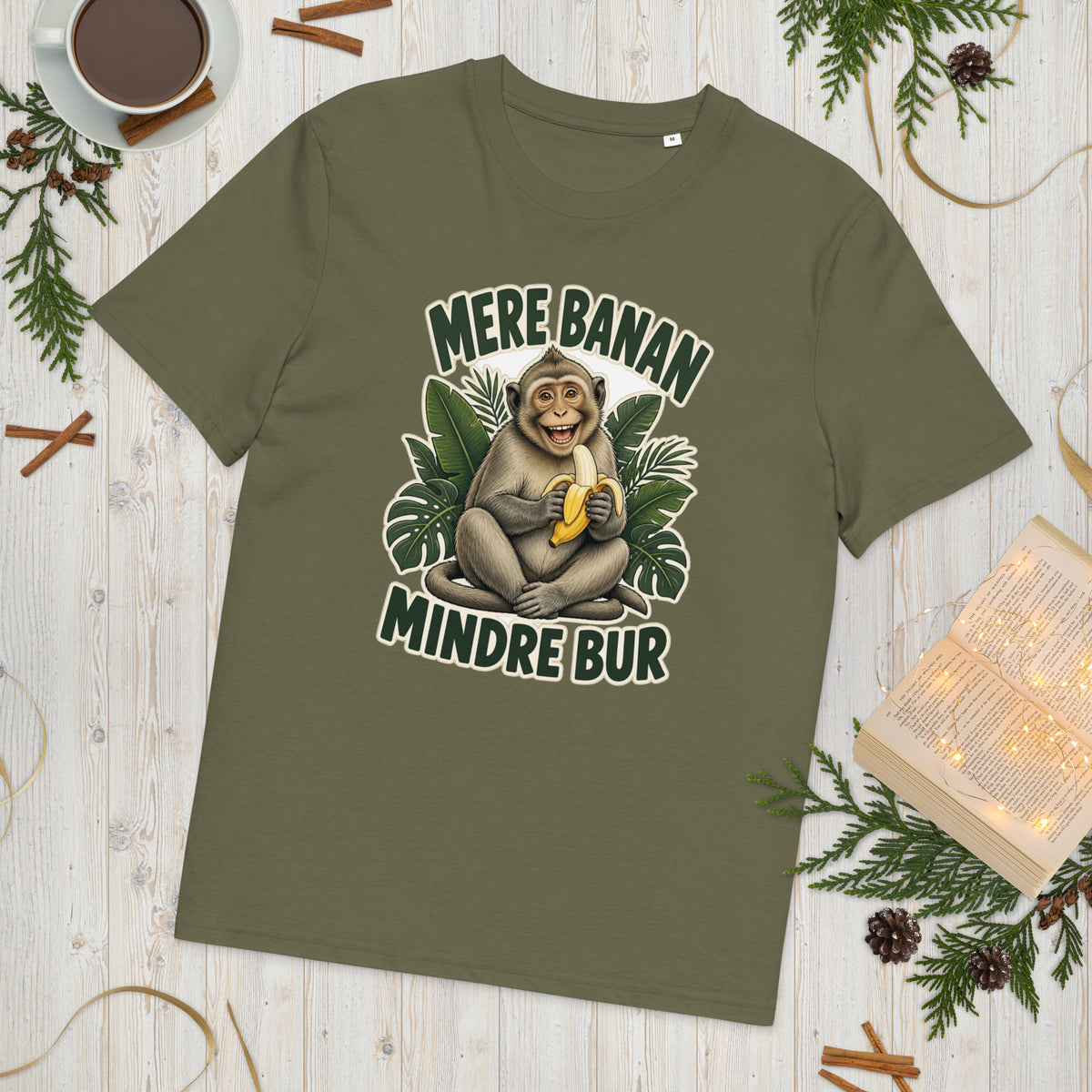 Abe t-shirt med teksten Mere banan, mindre bur i farven khaki, lagt på et lyst træbord