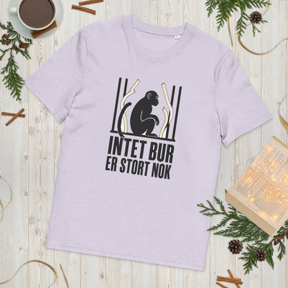 T-shirt med teksten Intet bur er stort nok i farven lavendel, lagt på et lyst træbord