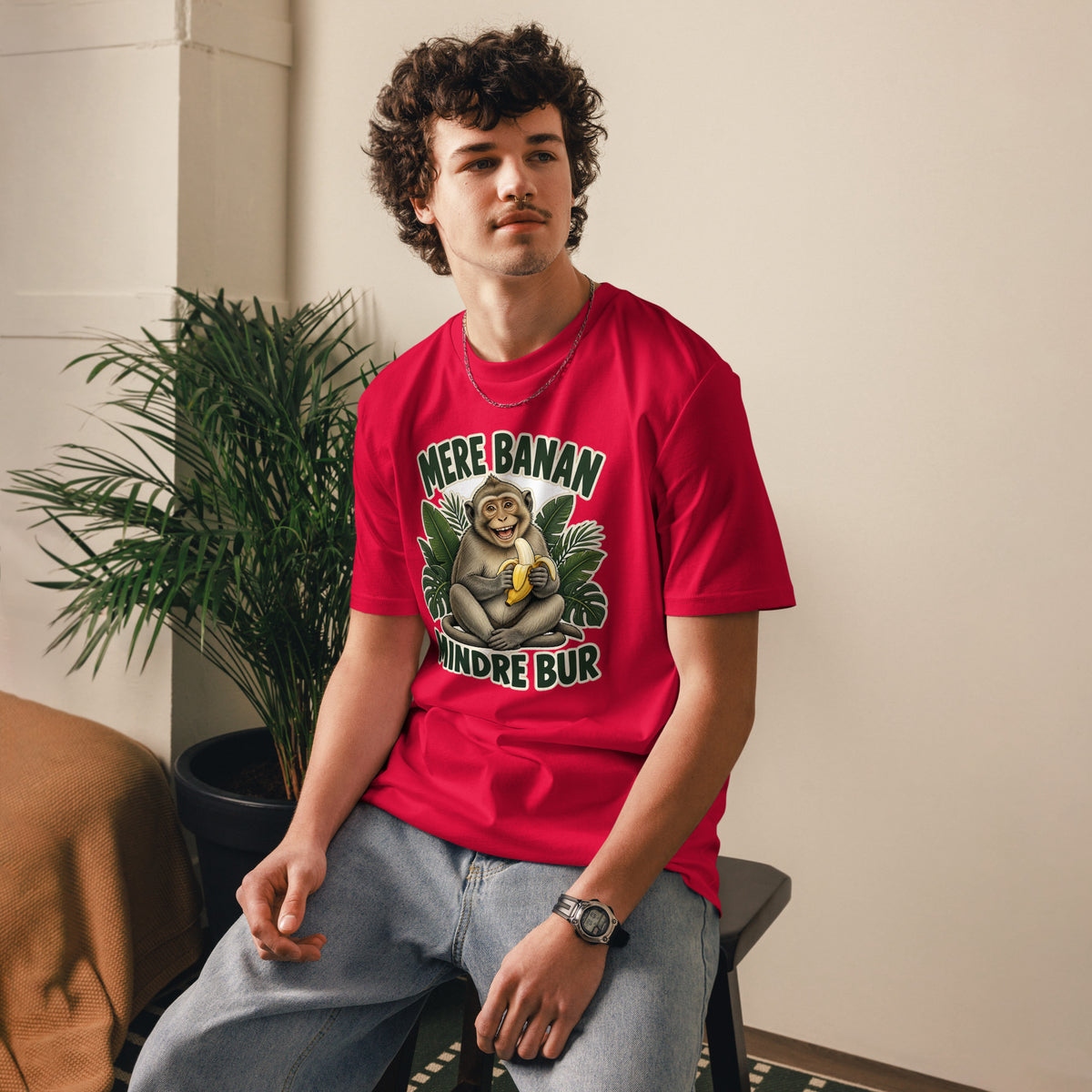 Abe t-shirt med teksten Mere banan, mindre bur i farven rød, båret af en ung mand