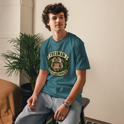 Freeman The Miracle Monkey t-shirt med abe i grønt badge i farven petroleumsblå, båret af en ung mand