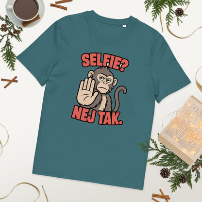 Sjov abe t-shirt med teksten Selfie? Nej tak. i farven petroleumsblå, lagt på et bord med kaffe og grønt