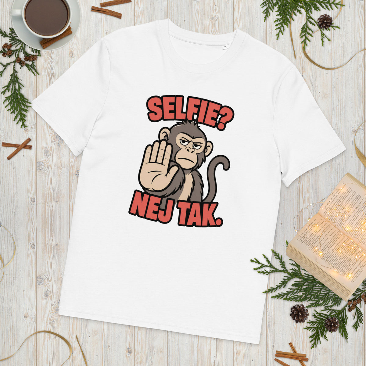 Sjov abe t-shirt med teksten Selfie? Nej tak. i farven hvid, lagt på et lyst træbord