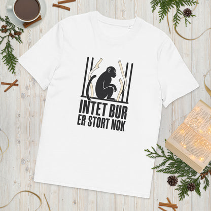T-shirt med teksten Intet bur er stort nok i farven hvid, lagt på et lyst træbord