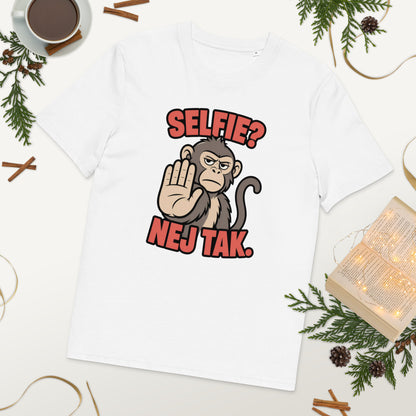 Sjov abe t-shirt med teksten Selfie? Nej tak. i farven hvid, lagt på et bord med kaffe og grønt