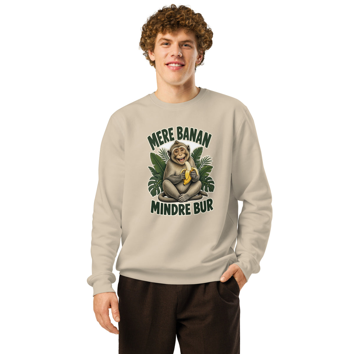 Sweatshirt med teksten Mere banan, mindre bur og en glad abe med en banan i farven sand, båret af en ung mand
