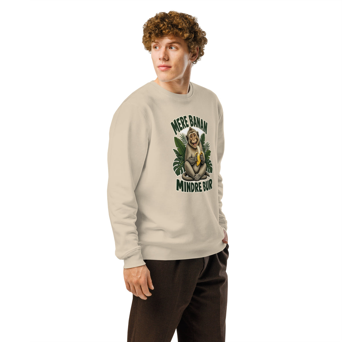 Sweatshirt med teksten Mere banan, mindre bur og en glad abe med en banan i farven sand, båret af en ung mand, set skråt