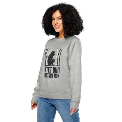Sweatshirt med teksten Intet bur er stort nok og en abe bag tremmer i farven lysegrå meleret, båret af en ung kvinde, set skråt